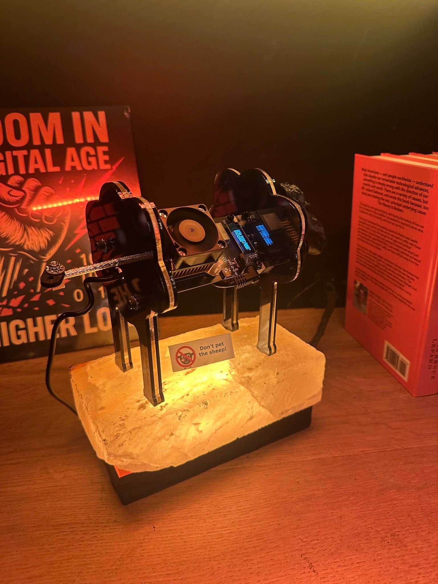 A sheep-shaped bitcoin miner on a lit stone base on the shelf, next to a sign reading “Don’t pet the sheep!”